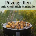 Champignons grillen | Marinade mit Knoblauch 1 Gegrillte Champignons auf dem Grill. Die Pilze werden mit einer Grillzange gedreht. Im Hintergrund Gras und Wasser. Pilze grillen ist ganz leicht