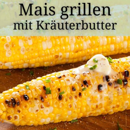 Gegrillter Mais auf einem Holzbrett, dekoriert mit Kraeuterbutter. Mais grillen mit veganer Kraeuterbutter
