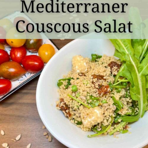 Mediterraner Couscous Salat mit Rucola, veganem Feta, getrockneten Tomaten und Tiefkuehlerbsen. Das Dressing ist vegan.