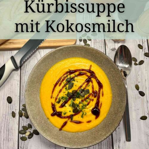 Kuerbissuppe mit Kokosmilch und geroesteten Kuerbiskernen, dekoriert mit Kraeutern, Kuerbiskernen und Balsamico Creme.