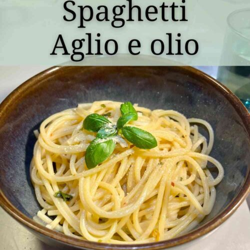 Spaghetti Aglio e olio mit Basilikum und Hefeflocken in einer braungrauen Schale.